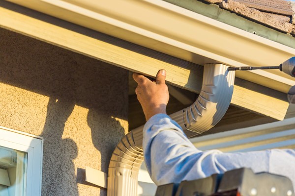 A Skabelund Roofing professional installing a roof gutter for a house in Cottonwood Heights, UT