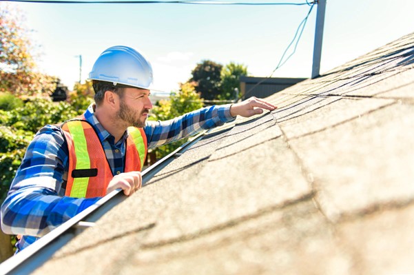 A Skabelund Roofing professional inspecting shingle roofs of a house in Cottonwood Heights, UT