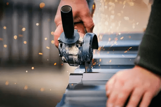 A technician using a circular saw to cut metal for roofing maintenance in Logan, UT
