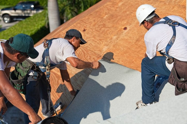 technicians performs roofing membrane
