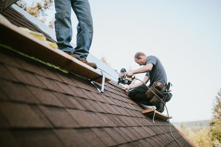 technicians-fixing-asphalt-shingles-roofing